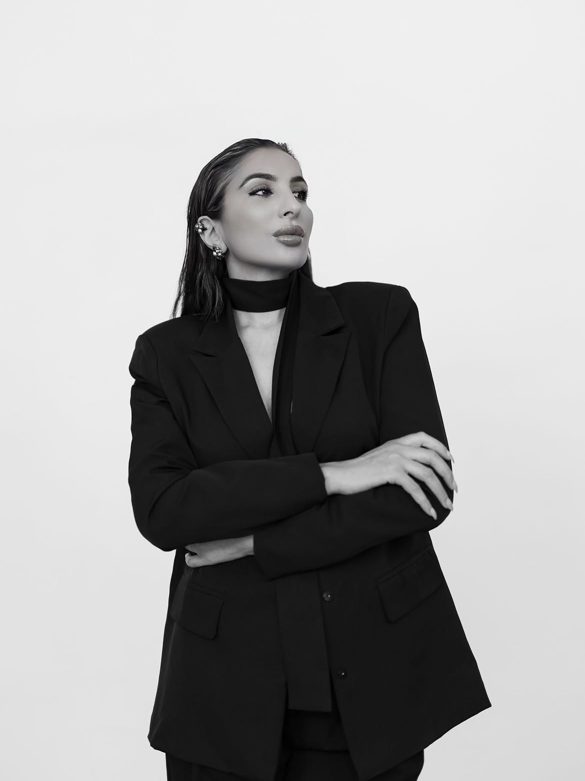 Black-and-white portrait of Kahina Melchane in a black blazer